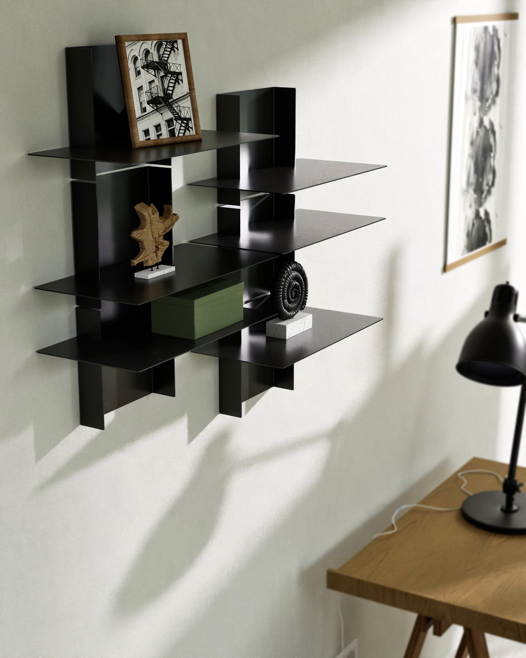 Two black modular wall shelves with books and decorative objects