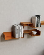 Orange modular wall shelves with books and bowl