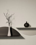 Black and white round metal wall shelves with vases