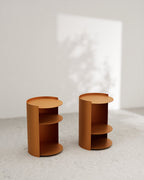 Terracotta metal nightstands with open side shelves on concrete floor