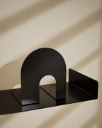Black metal bookends displayed together on a shelf