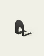 Black metal bookend with rounded arch shape on light background
