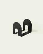 Black metal bookend with open arch shape on light background