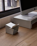 White metal pen holder with folded front edge with pens