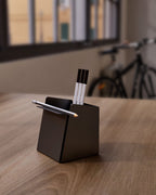 Black metal pen holder with folded front edge with pens