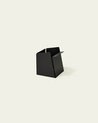 Black metal pen holder with folded front edge on light background