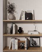 Black, white, and terracotta metal bookends styled on open wooden shelving