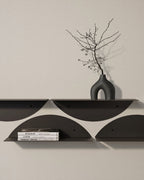 Grouped black round wall shelves with books and vase