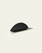 Black round metal wall shelf on light background
