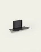 Black modular metal shelf on light background
