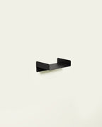 Black metal wall shelf on light background