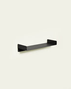 Black metal wall shelf on light background