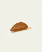 Terracotta round metal wall shelf on light background