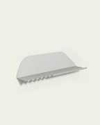 White metal wall shelf with hooks on light background
