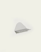 White metal wall shelf with hooks on light background