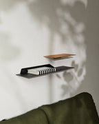 Black and terracotta slim wall shelves mounted above sofa