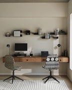 Black modular wall shelves above desk with books and objects