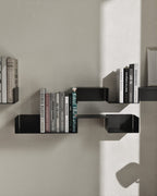Black modular wall shelves mounted vertically with books