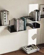 Black modular wall shelves mounted vertically with books
