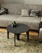 Black modular coffee table in round configuration in front of sofa