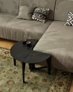 Black modular steel coffee table arranged as a half-round side table