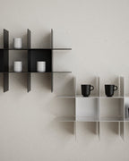 Close-up of modular wall shelves with mugs and small objects