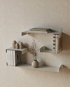 White metal wall shelves with books and decorative objects
