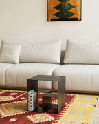 Black modular coffee table in front of white sofa with books