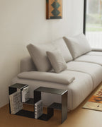 Two black modular coffee table sections used separately beside sofa