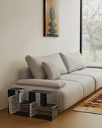 Black modular coffee table sections arranged in open layout beside sofa