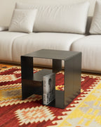 Black metal coffee table with built-in book storage in front of sofa