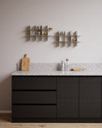 Two white modular wall shelves above kitchen counter with jars and bowls