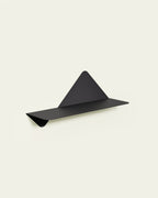 Black modular metal wall shelf on light background