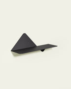 Black modular metal wall shelf on light background in reversed layout