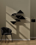 Grouped black modular wall shelves mounted on wall beside chair and floor lamp