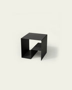 Black modular metal coffee table on light background