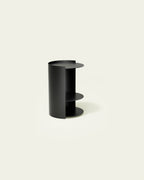 Black metal nightstand with open side shelves on light background